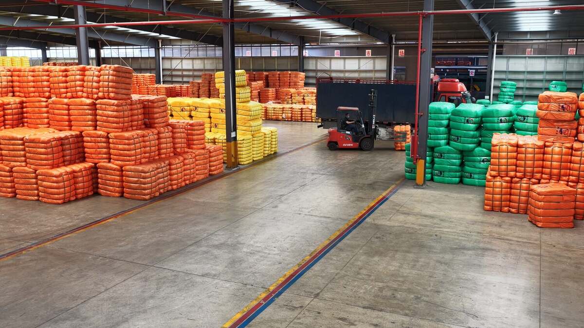 Dafa warehouse full of packed recycled polyester staple fiber bales with forklift